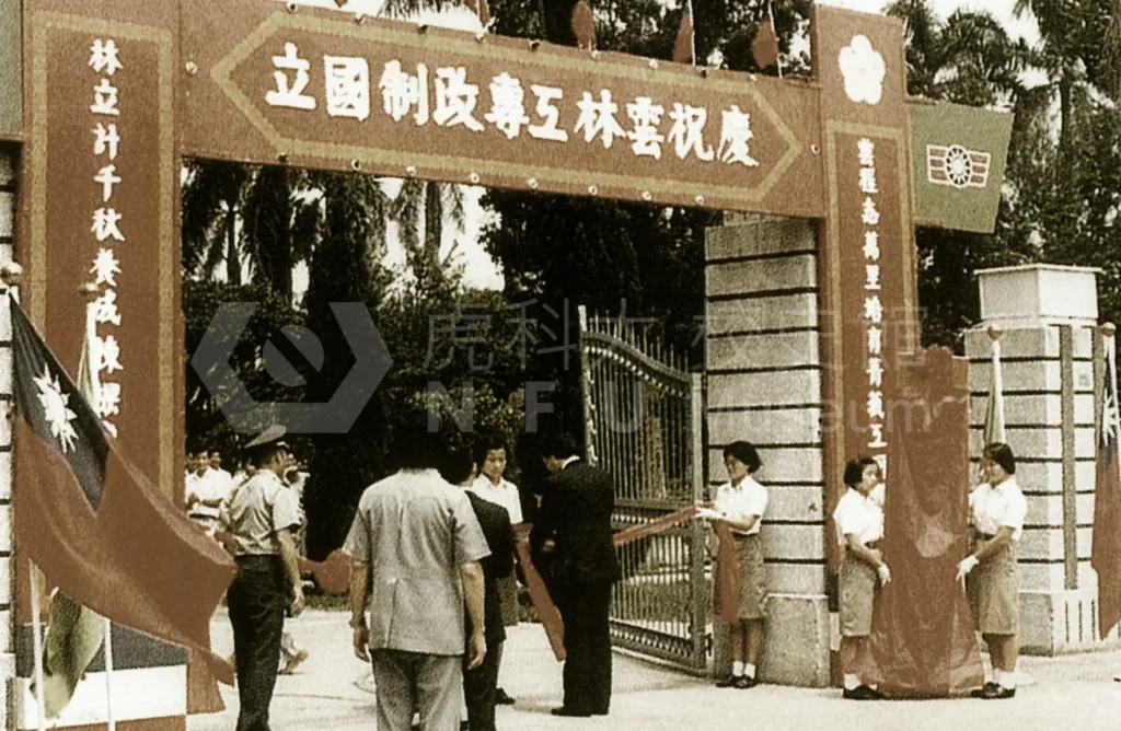 A group of people stand in front of a gate celebrating Yunlin Institute of Technology being upgraded to a national university。